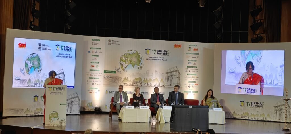 Dr. Vibha Dhawan delivering the opening address at the 17th GRIHA Summit 2025 in New Delhi, with panelists seated on stage and the event backdrop displaying the theme “Innovate to Act for a Climate-Resilient World.”