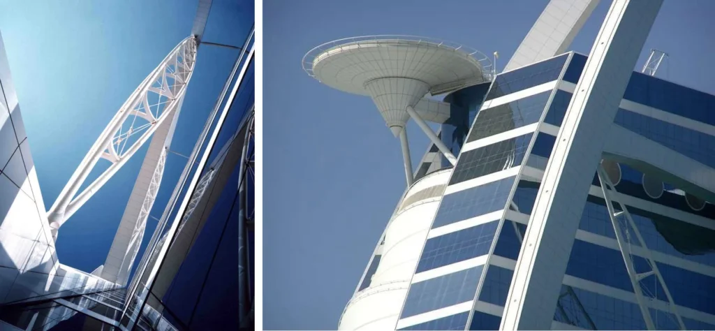 Upward view of the Burj Al Arab’s steel structural arch and exterior components contrasting against a clear blue sky.