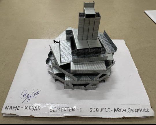 Stapler-pin architectural model created by first-year architecture student Kesar at DSEU Aryabhatta Campus, showcasing layered geometric forms and a central tower.