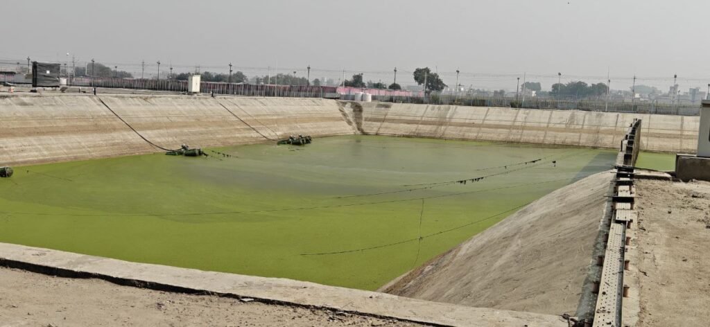 A large water lagoon at the Sant Nirankari Samagam site used for wastewater treatment and recycling.
