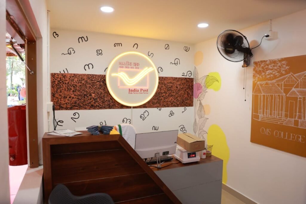 Aesthetically designed interior of the Gen-Z Post Office Extension Counter at CMS College, featuring a modern service desk, India Post branding, and student-created artwork.