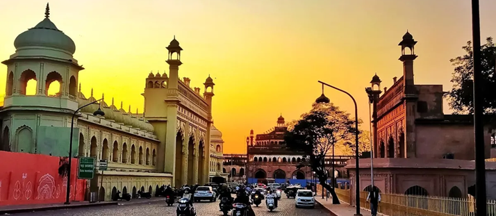 Evening view of historic buildings in Lucknow with the skyline glowing at sunset, showcasing the city's architectural charm.