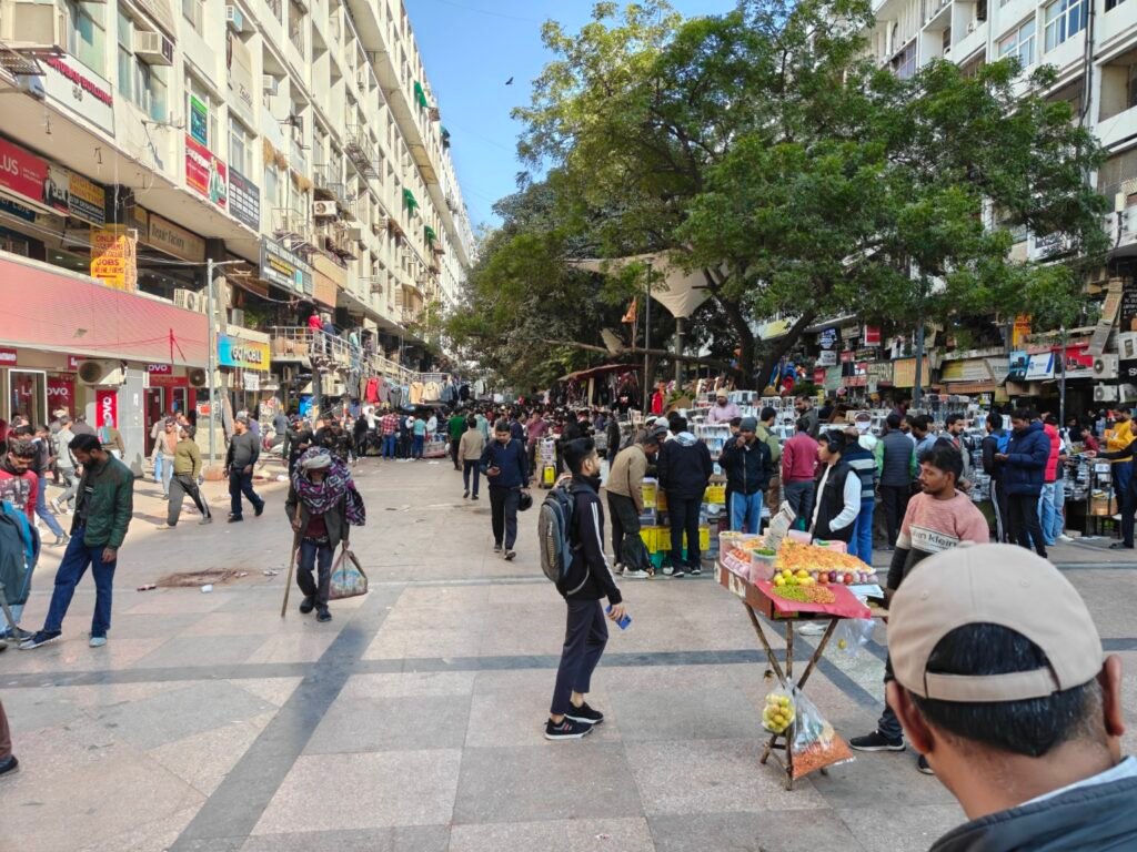 Informal street market occupying shaded public plaza under trees at Nehru Place, Delhi