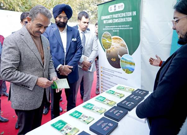 Union Environment Minister reviewing publications at an exhibition on community participation in wetland conservation during World Wetlands Day 2026