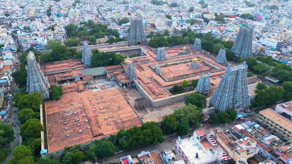 Aerial view of Meenakshi Amman Temple complex showing gopurams, prakarams and surrounding Madurai city