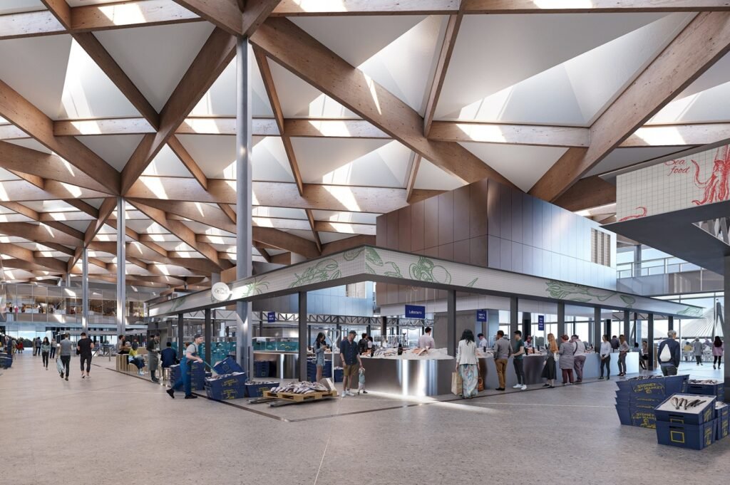Interior market hall of the Sydney Fish Market with seafood counters, shoppers, and the exposed glulam timber roof grid above.