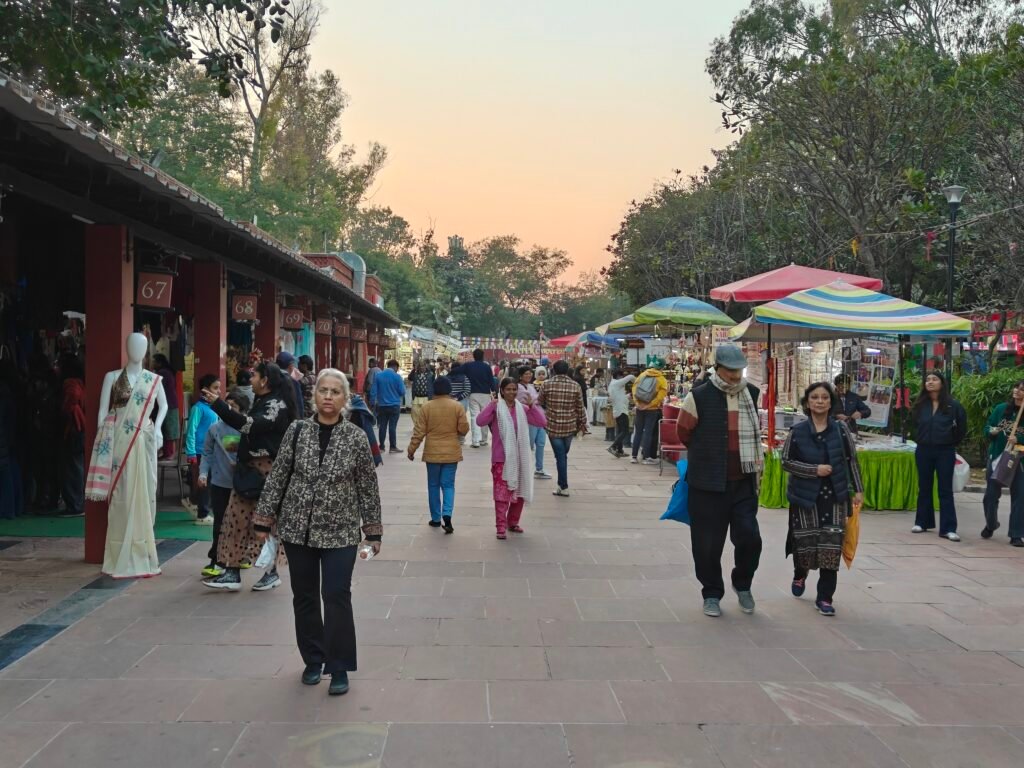 Bazaar street at Dilli Haat INA with stalls, shoppers and evening activity