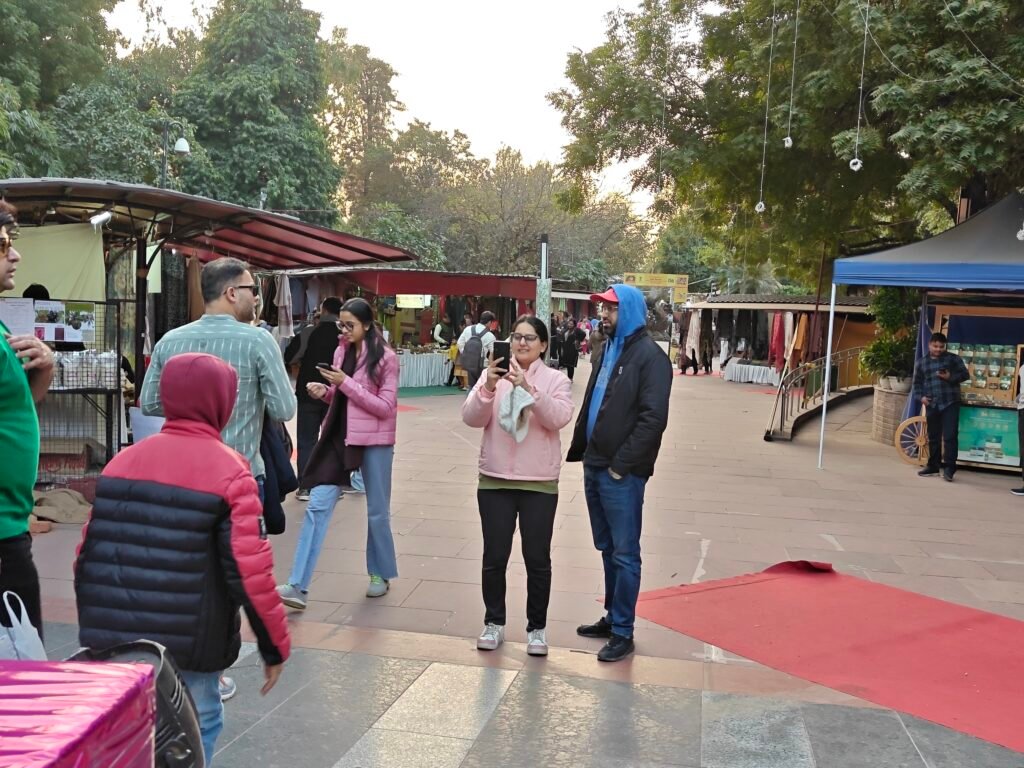Visitors walking through temporary stalls and event setup at Dilli Haat INA Delhi
