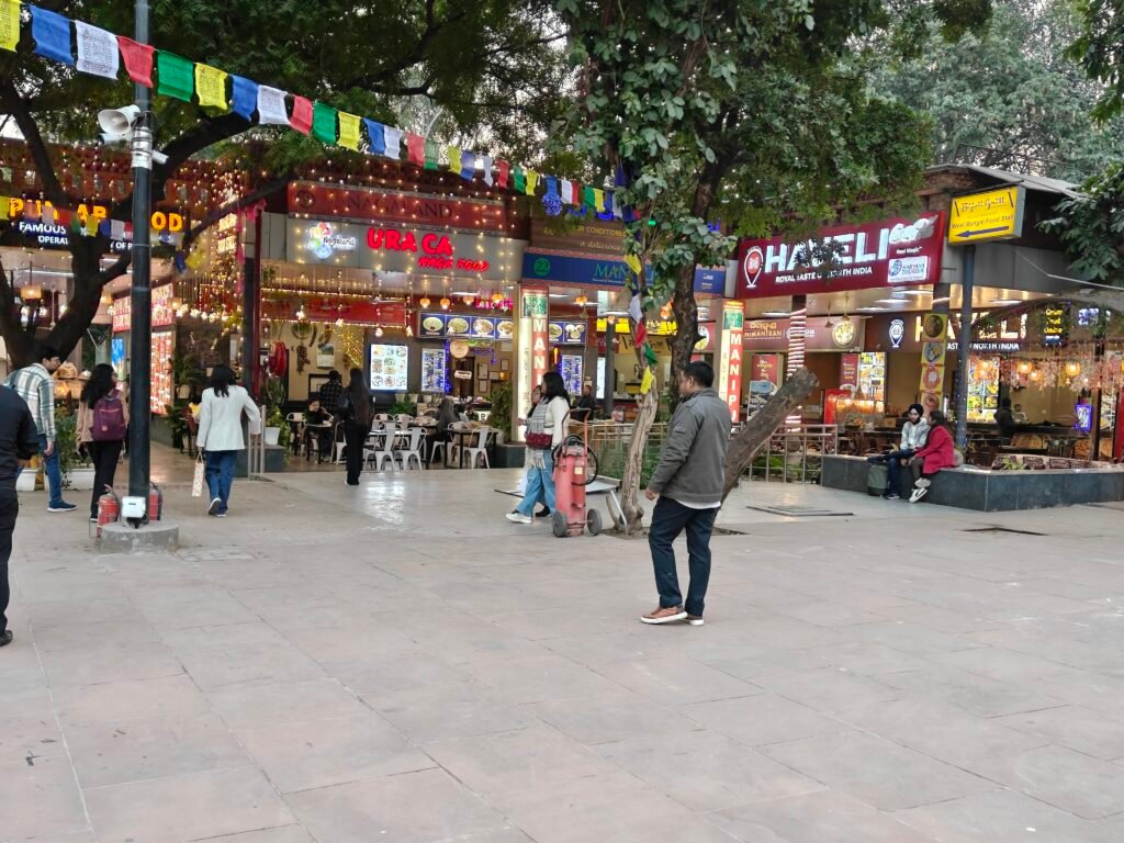 Food court and public plaza at Dilli Haat INA with regional food stalls and visitors