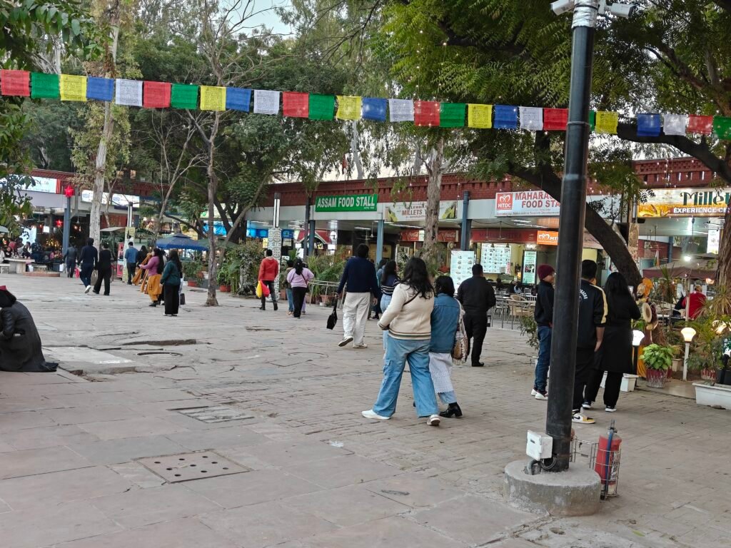 Visitors walking along food street and activity zone at Dilli Haat INA