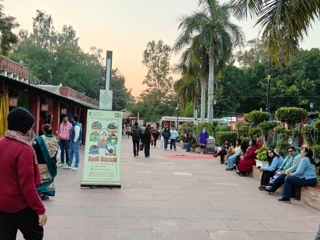 Main pedestrian walkway at Dilli Haat INA with craft stalls and visitors