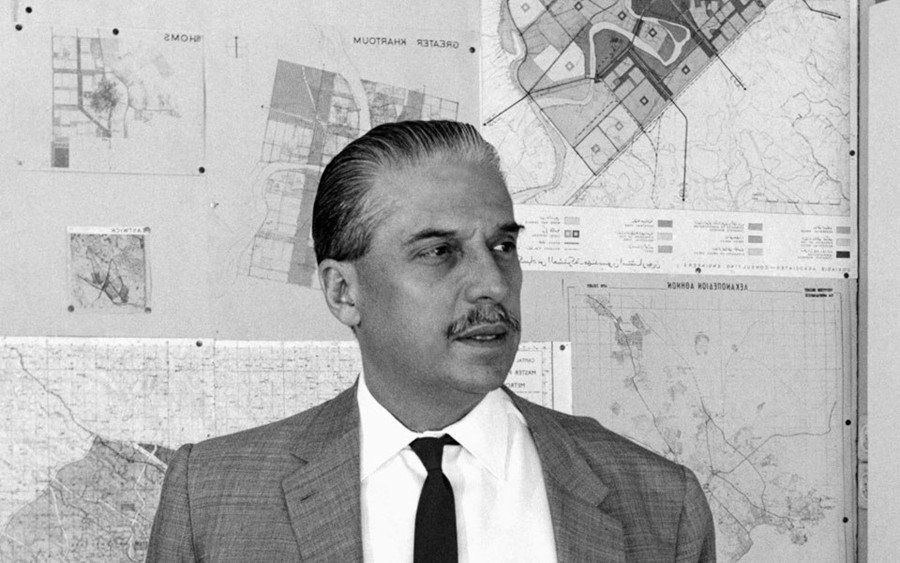 Constantinos Doxiadis portrait with urban planning maps in background