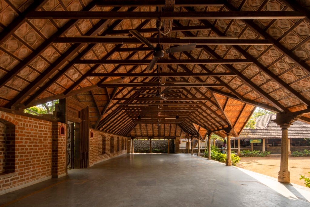 Traditional restaurant veranda with timber roof and brick walls at Dakshinachitra