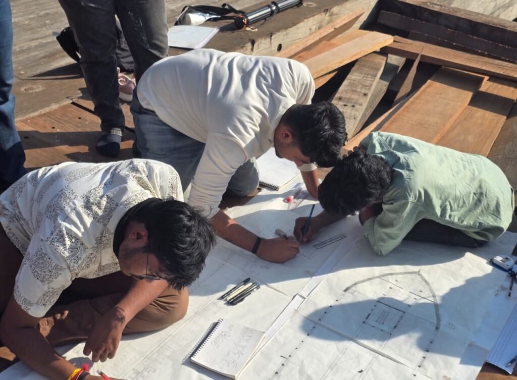 Students preparing detailed architectural drawings of a traditional wooden ship