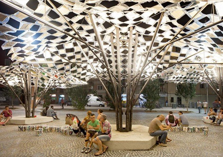 Illuminated public installation with suspended books and seating area designed by Anupama Kundoo at night