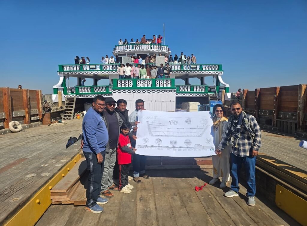 Students presenting architectural drawings of traditional boat on ship deck