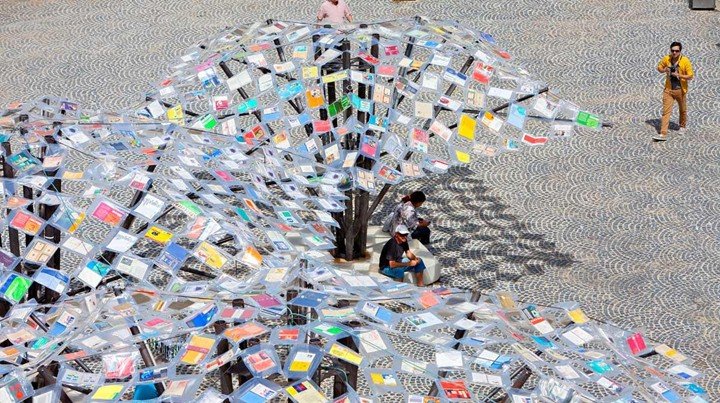 Overhead view of architectural canopy made from suspended recycled books in public space installation