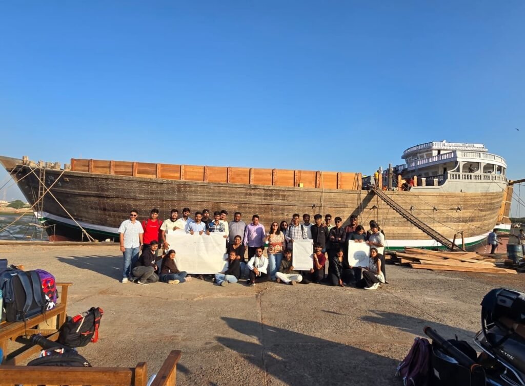 Architecture students from SAL School of Architecture standing in front of a traditional wooden ship in Mandvi Gujarat