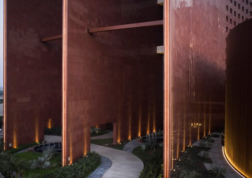 Illuminated red sandstone facade and landscape pathway at Surat Diamond Bourse