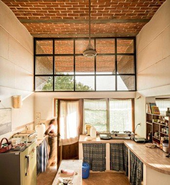 Sustainable kitchen interior with exposed brick ceiling and natural daylight designed by Anupama Kundoo