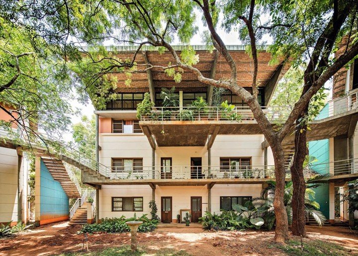 Multi-level sustainable residential building surrounded by trees designed with exposed concrete and brick architecture