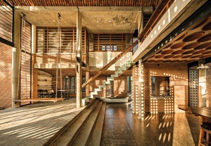 Sunlit interior of Wall House featuring terracotta ceiling modules and exposed brick architecture by Anupama Kundoo