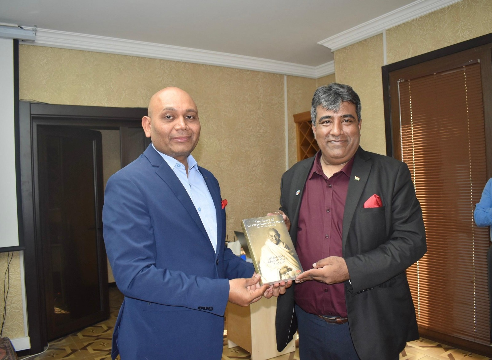 Architect Rajendra Kumar presenting a book during an international cultural exchange meeting.