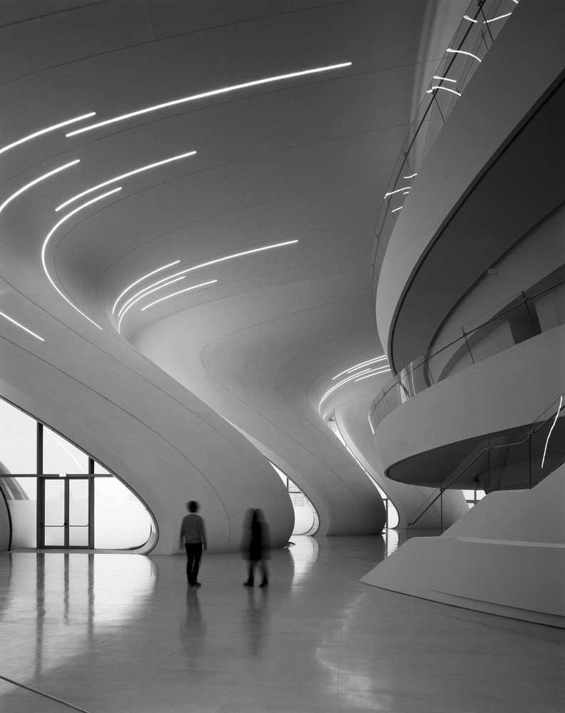 Minimalist interior gallery of the Heydar Aliyev Center with flowing white architectural forms.