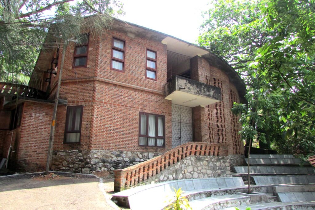Side view of Laurie Baker’s exposed brick auditorium at CDS