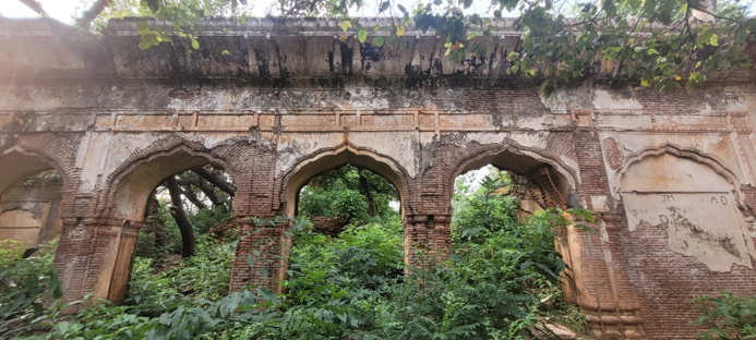 Repeated arched openings in a weathered brick and plaster structure at Jasrota Fort.